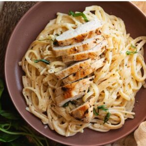 Fetuccini Alfredo con tocino y pollo , pan con ajo | Aldebarán