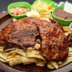 Chuleta asada, frijoles fritos con tajadas de guineo Verde, ensalada de repollo (Aldebarán)